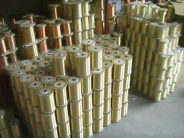 Several small coils of brass wires are piled neatly in the warehouse.