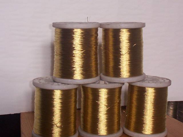 Five small coils of brass wire on white spool.