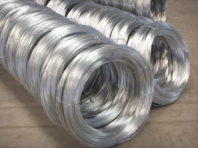 Several big coils of galvanized wires are neatly placed in the warehouse.