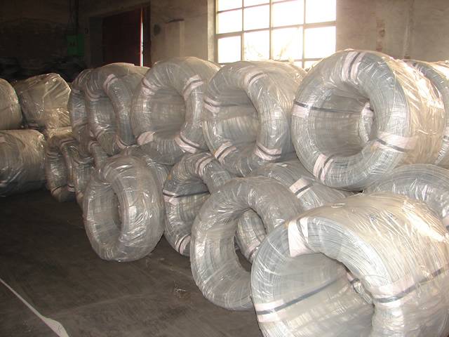 Several big coil of galvanized wires in plastic film package are piled up