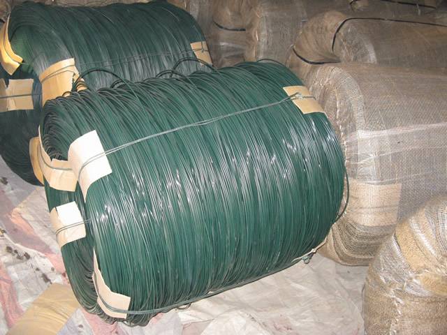 Two big coils of PVC coated wires on the ground and several coils are packed in woven bag.