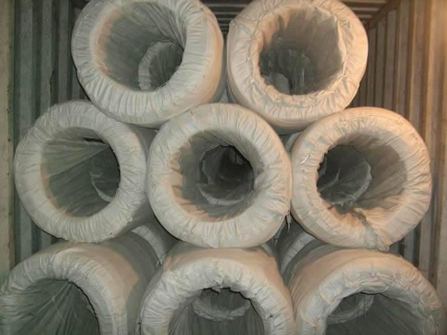 Several big coils of PVC coated wires in woven bag package in the container.