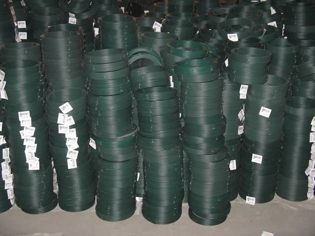 Some small coil of dark green PVC coated wires attached with labels are piled up on the ground.