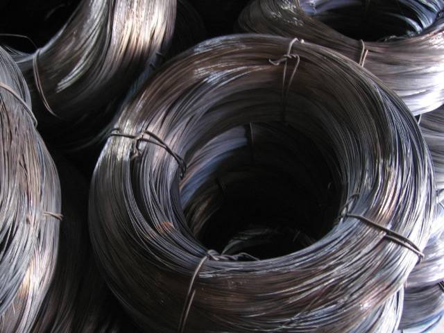 Several rolls of black steel wire on the ground.