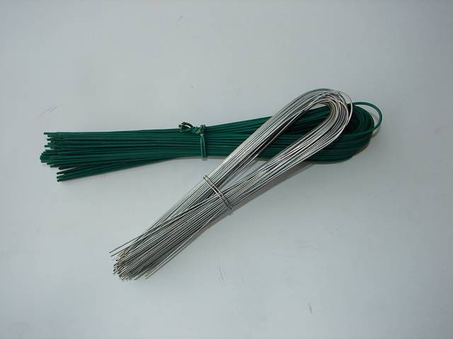 A roll of PVC coated and A roll of galvanized U type wire on the table.